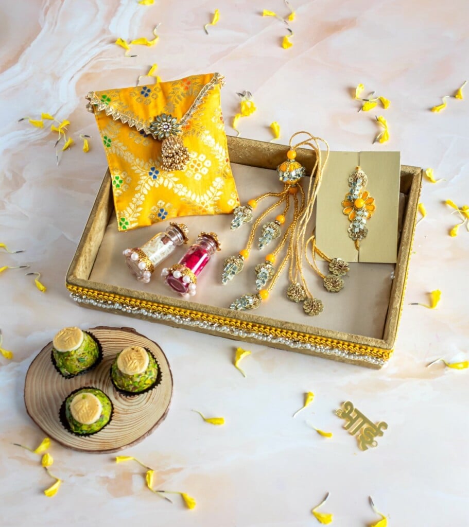 Floral Art presents A decorative tray with jewelry, perfume bottles, and gift items is displayed alongside a plate of sweets and scattered flower petals.