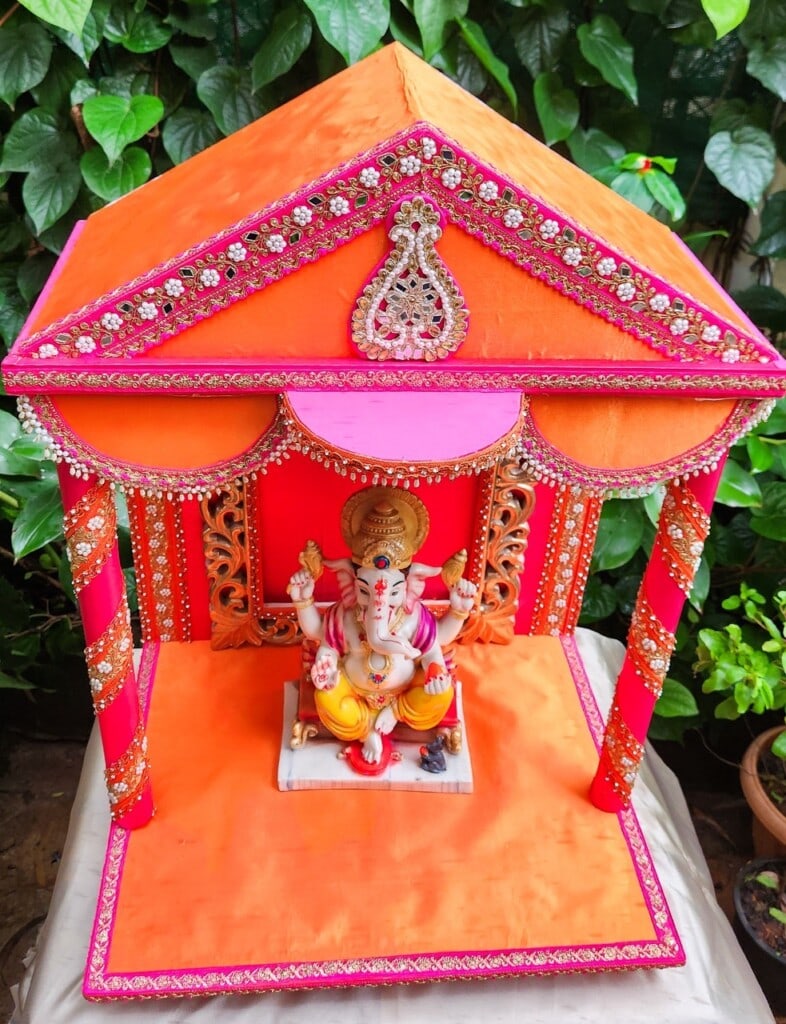 Floral Art presents A colorful altar with a decorated canopy houses a statue of Lord Ganesha.