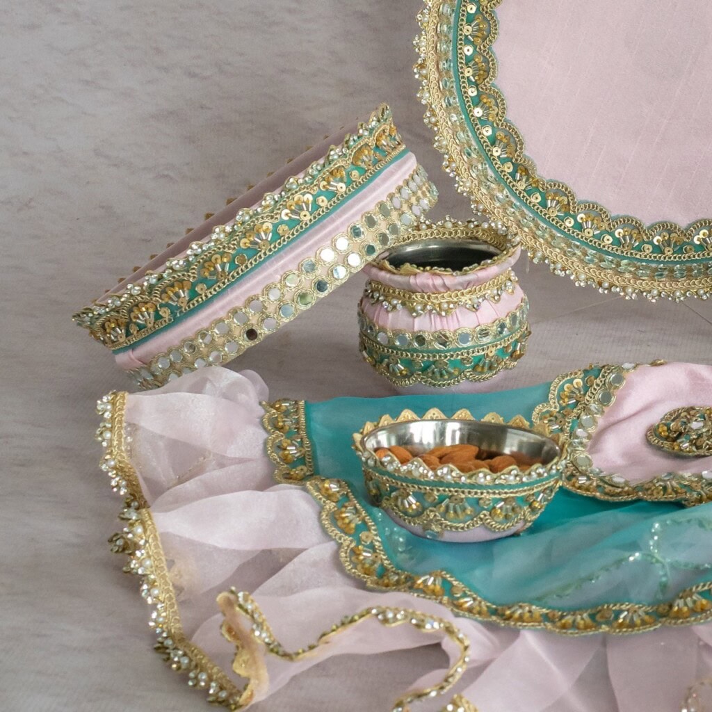 Floral Art presents A set of decorative trays and containers with gold, turquoise, and pink embellishments, displayed on a light surface.